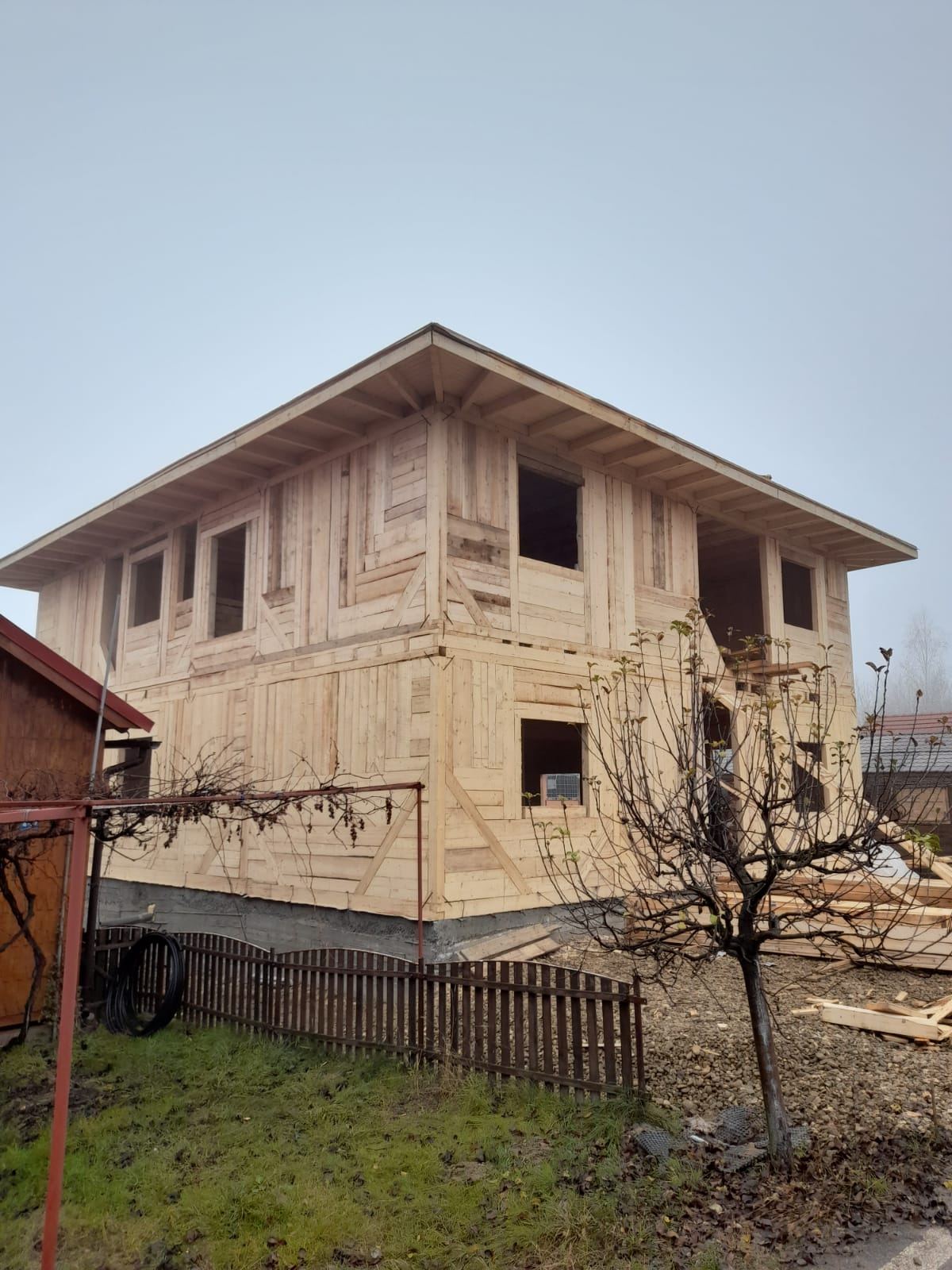 Casă din lemn la roșu, etaj cu ferestre